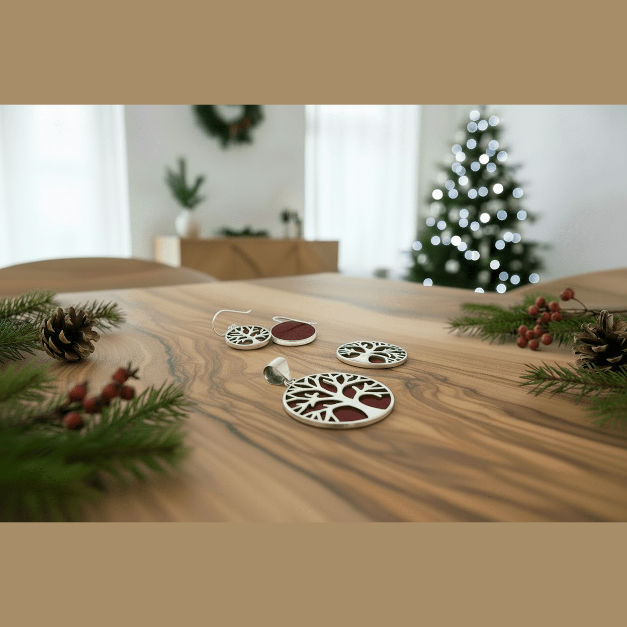 Christmas jewellery on a wooden table with a blurred Christmas tree in the background.