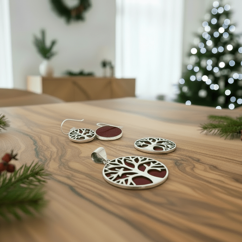 Christmas jewellery on a wooden table with a blurred Christmas tree in the background.