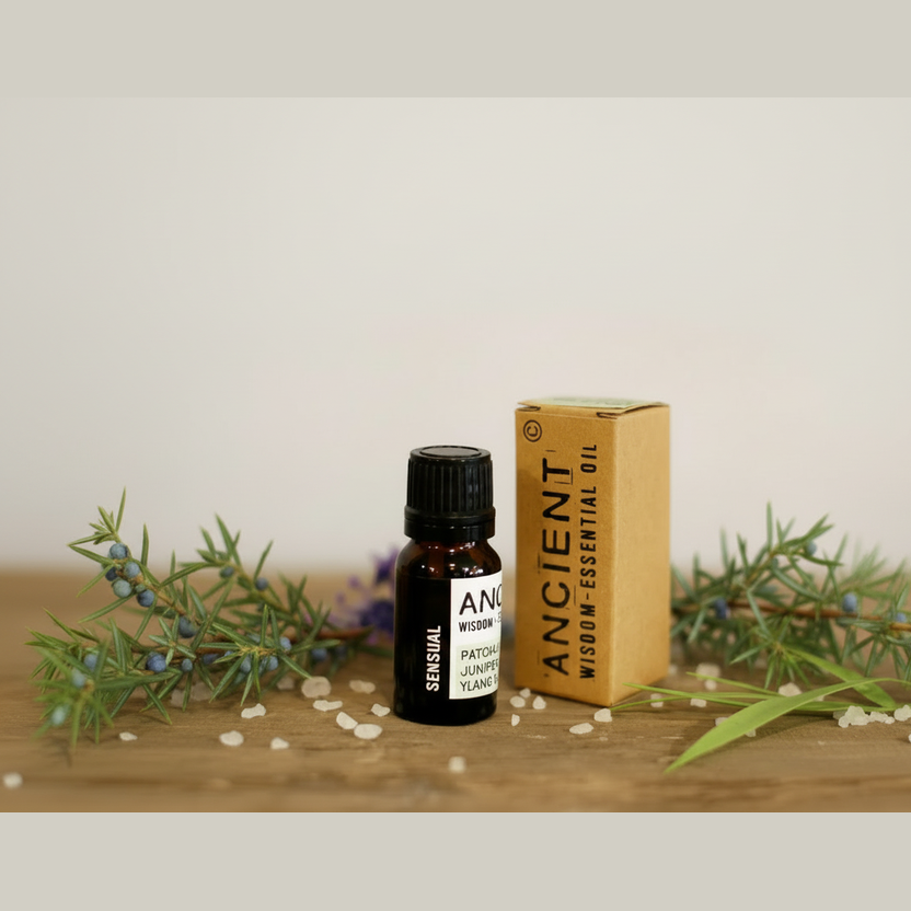 Essential oil bottle and packaging with greenery on a wooden surface