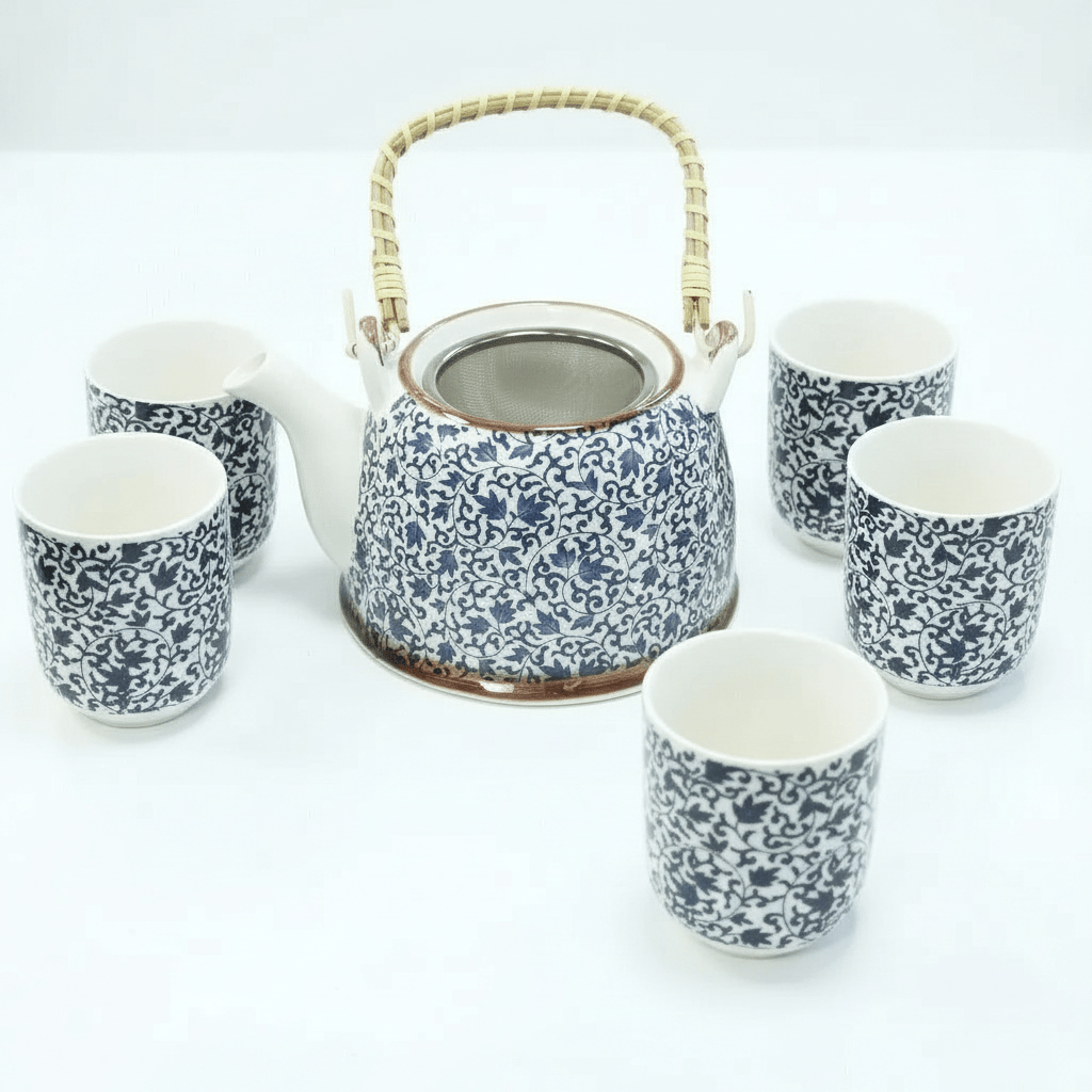 Ceramic teapot and cups with floral pattern on a white background