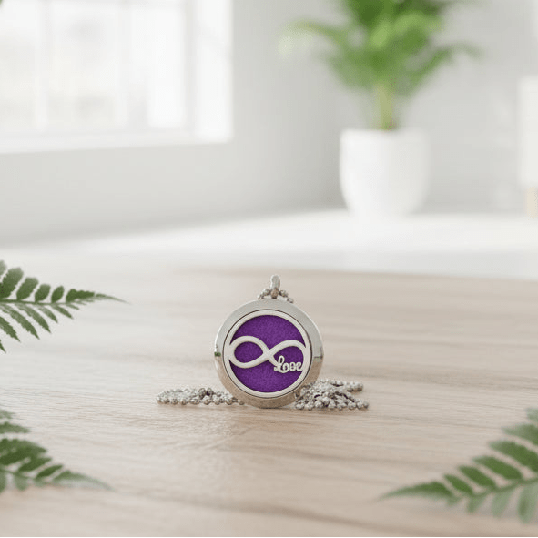 Necklace with a purple pendant on a light surface with green leaves in the background