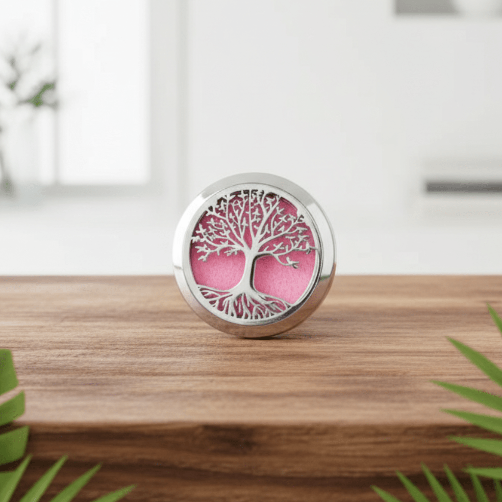 Decorative diffuser with tree of life design on a wooden surface with green leaves in the foreground