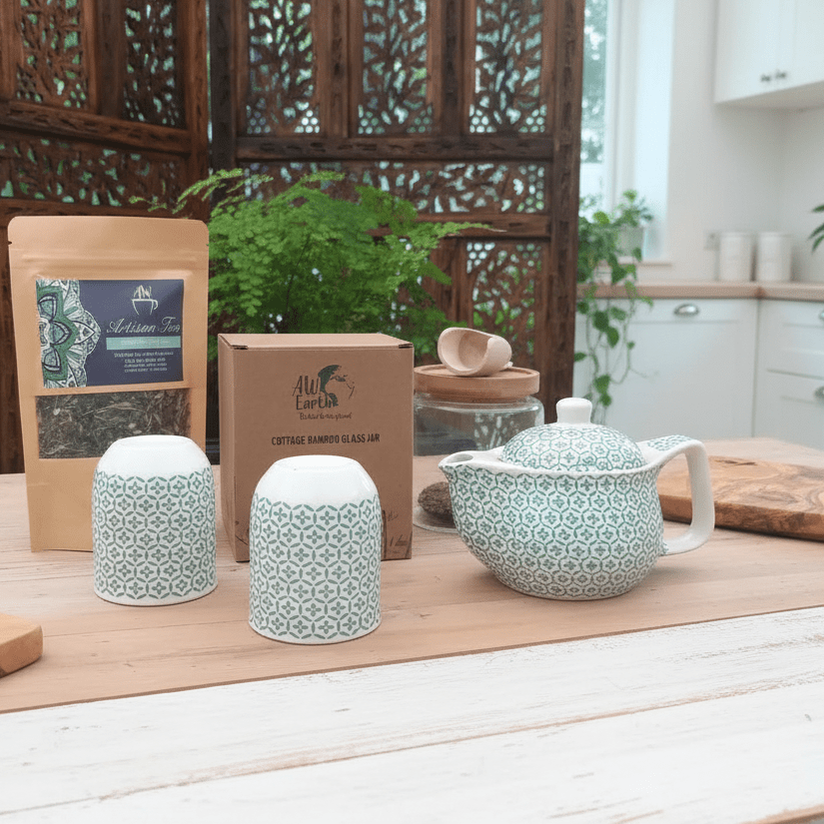 Tea set with green and white pattern on a wooden table in a kitchen setting.