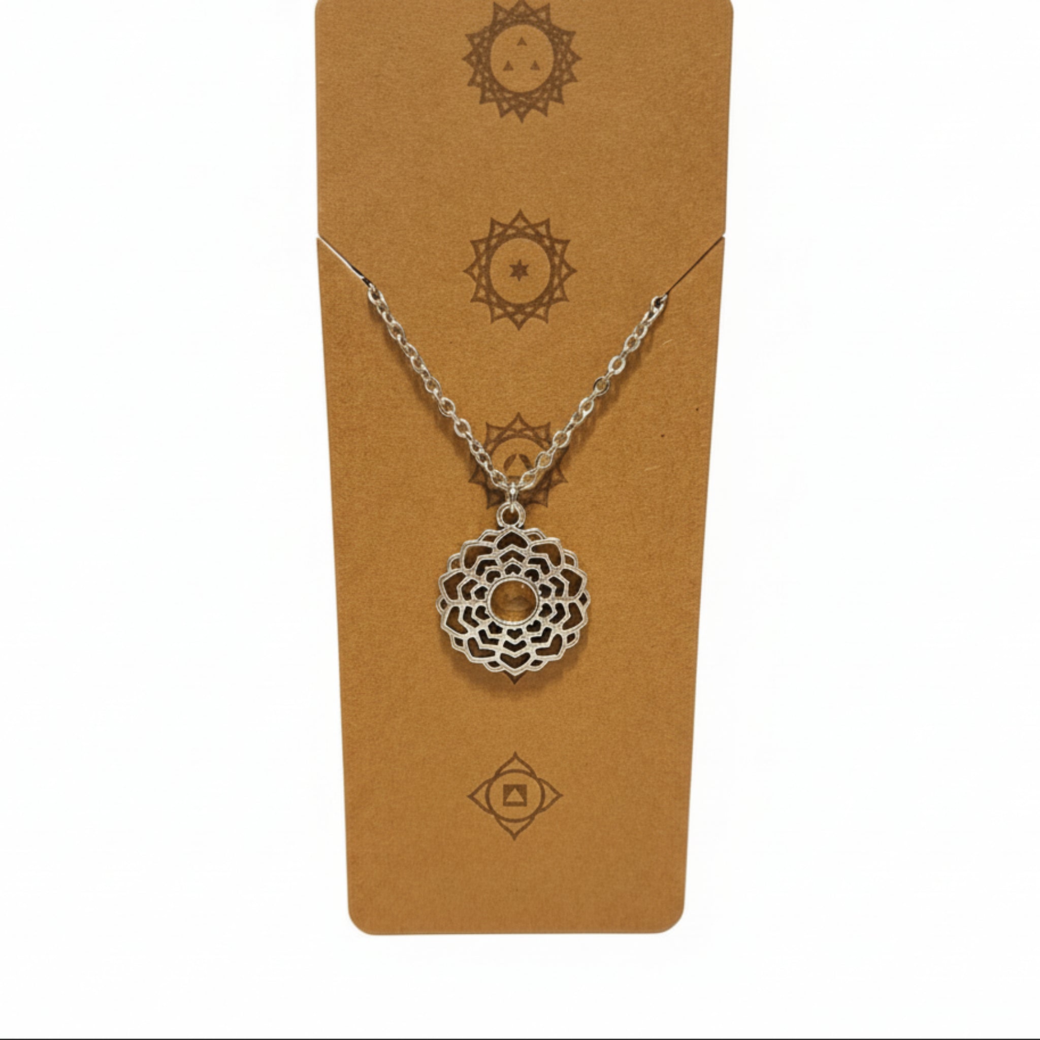 Silver necklace with a decorative pendant on a brown card with sun designs.