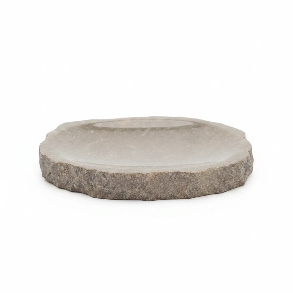 A round stone soap dish with a rustic, rough-textured grey outer rim and a smooth, polished light gray center, shown on a plain white background.