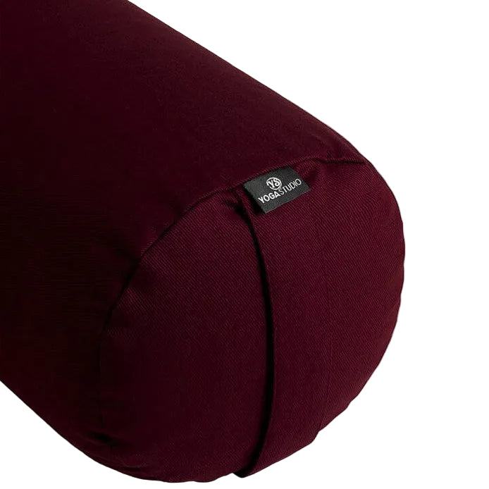 Maroon yoga bolster with a visible brand label on a light gray background