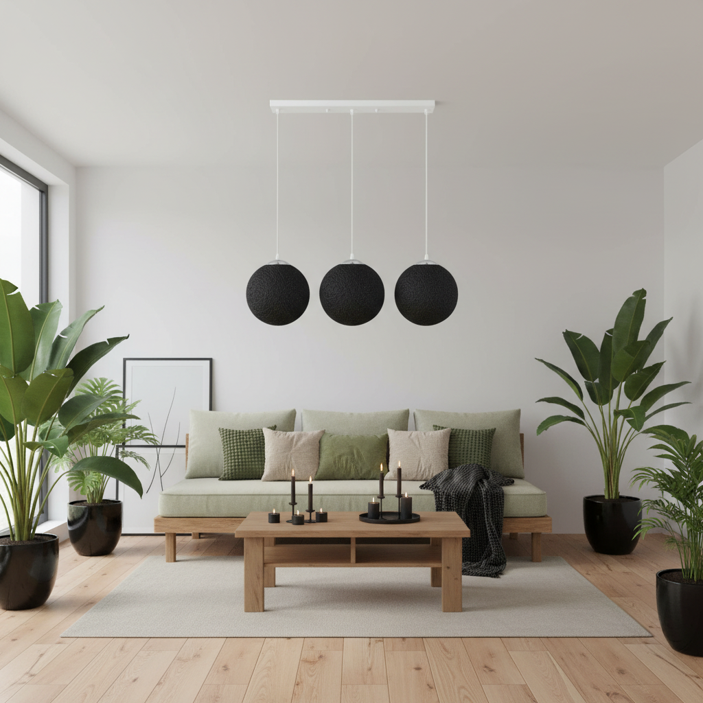 A modern living room with a light wood floor, a beige sofa with green cushions, a wooden coffee table, and three black spherical pendant lights hanging from a white ceiling.