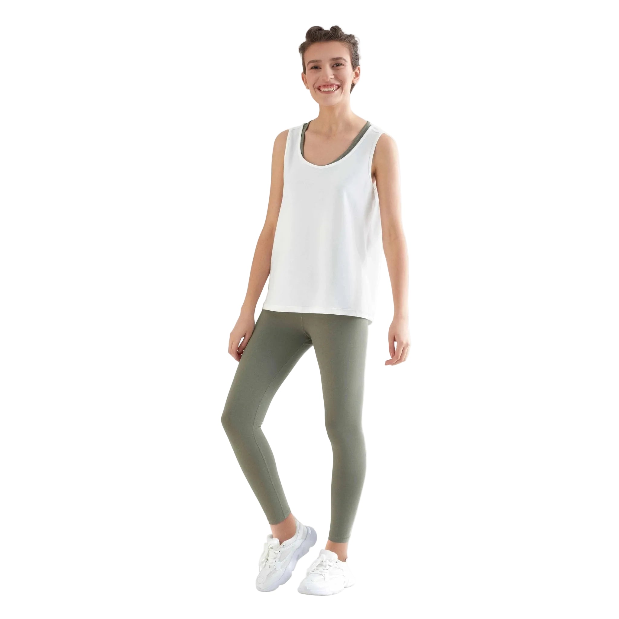 Woman wearing a white tank top and green leggings on a white background