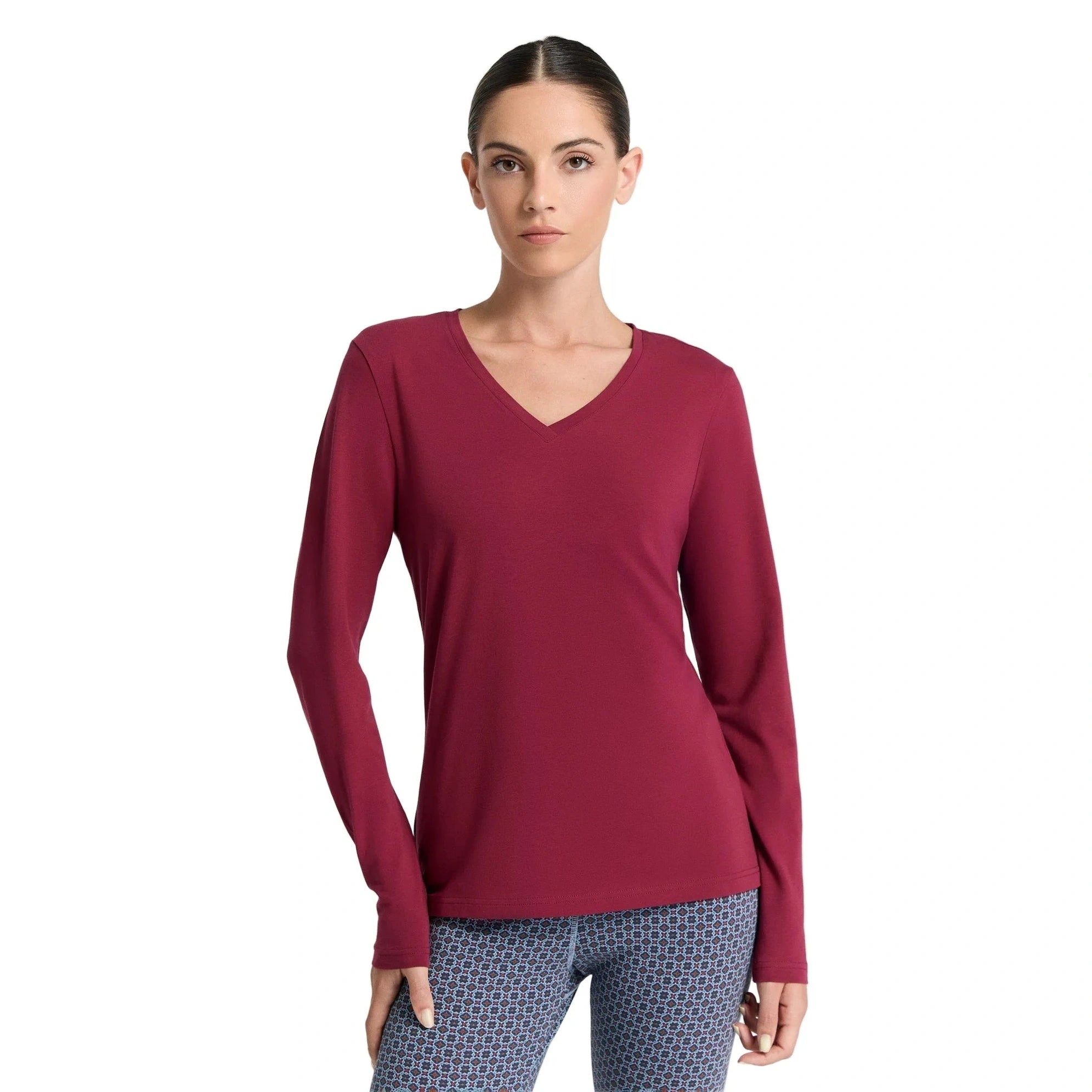 Woman wearing a maroon long-sleeve top on a white background
