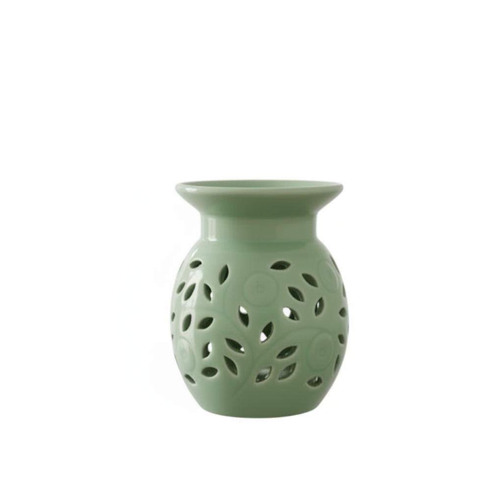 Green ceramic oil burner with decorative holes on a white background