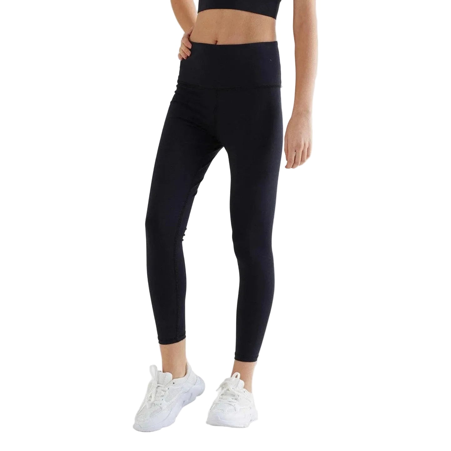 Person wearing black leggings and white sneakers on a light gray background