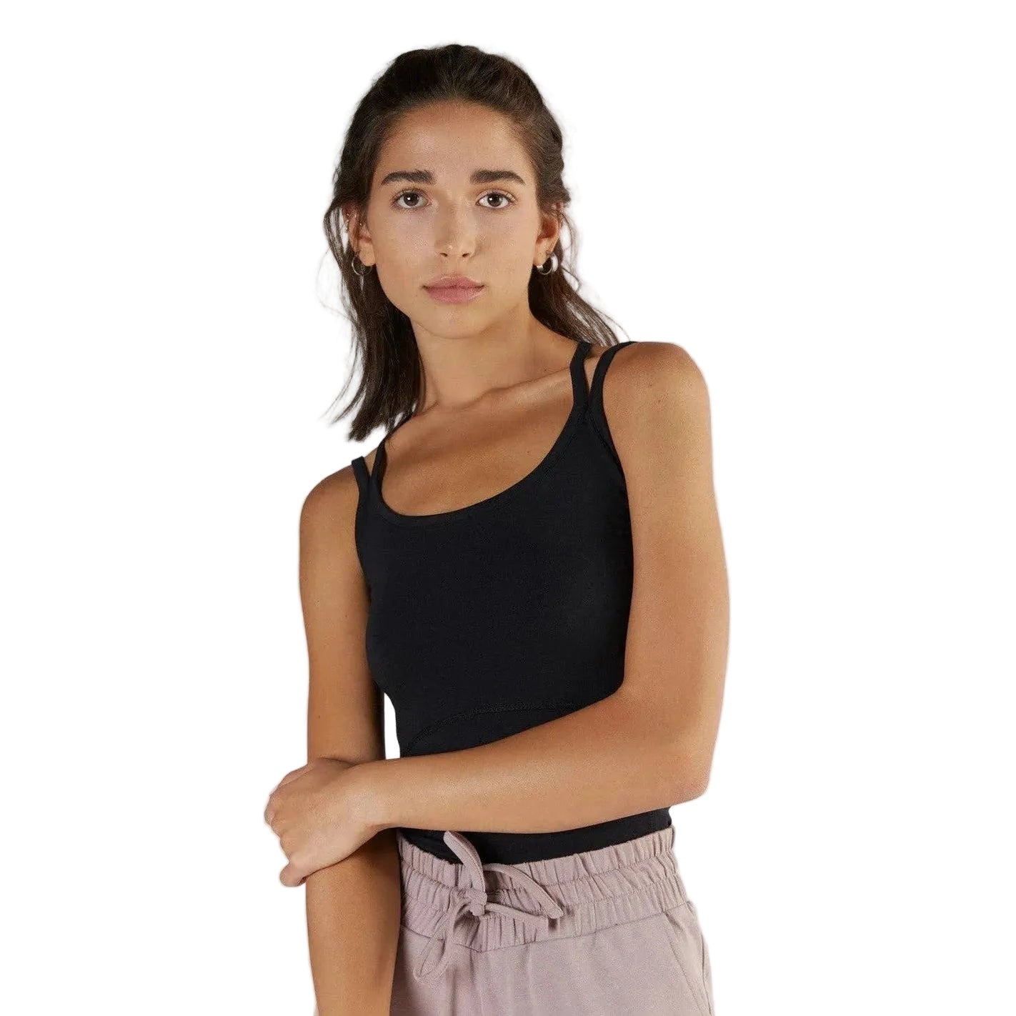 Woman wearing a black tank top and light pink pants against a white background