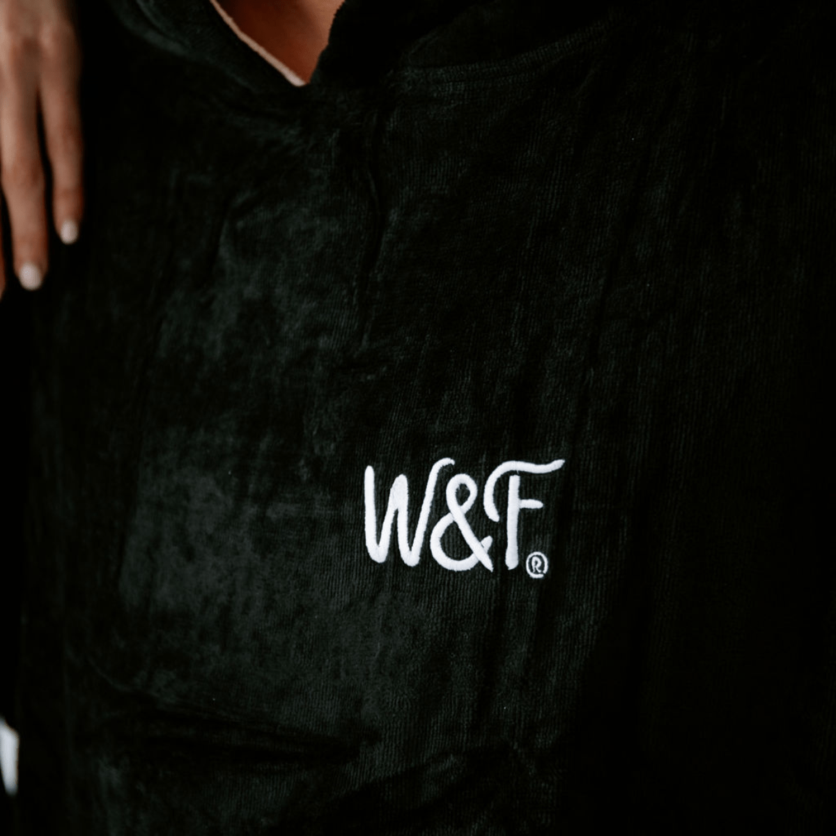 Black hooded towelled robe with 'W&F' logo on a dark background