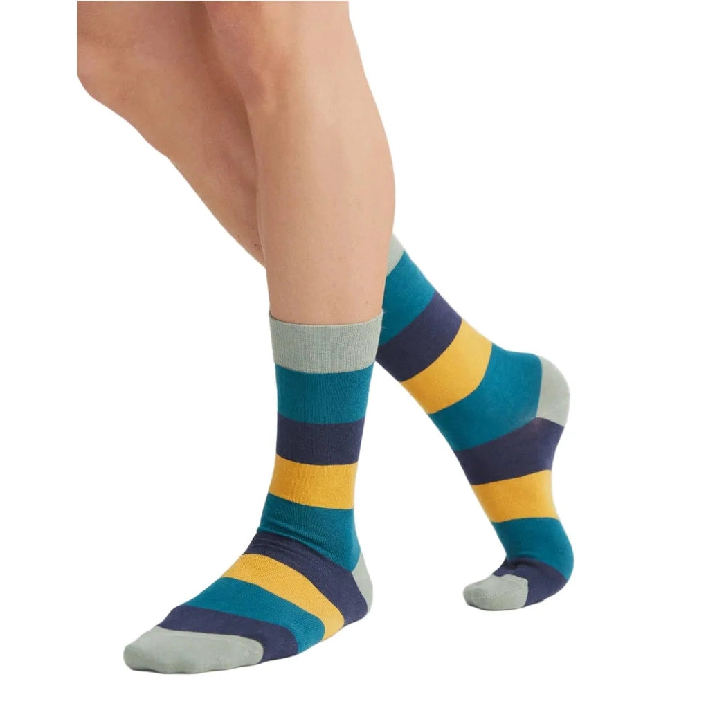 Colorful striped socks worn by a person on a white background