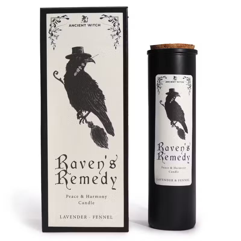 A black cylindrical candle jar with a cork top stands beside its matching black-and-cream box. The label shows a black raven wearing a hat, with the text 'Ancient Witch Raven's Remedy' and 'Lavender - Fennel'.