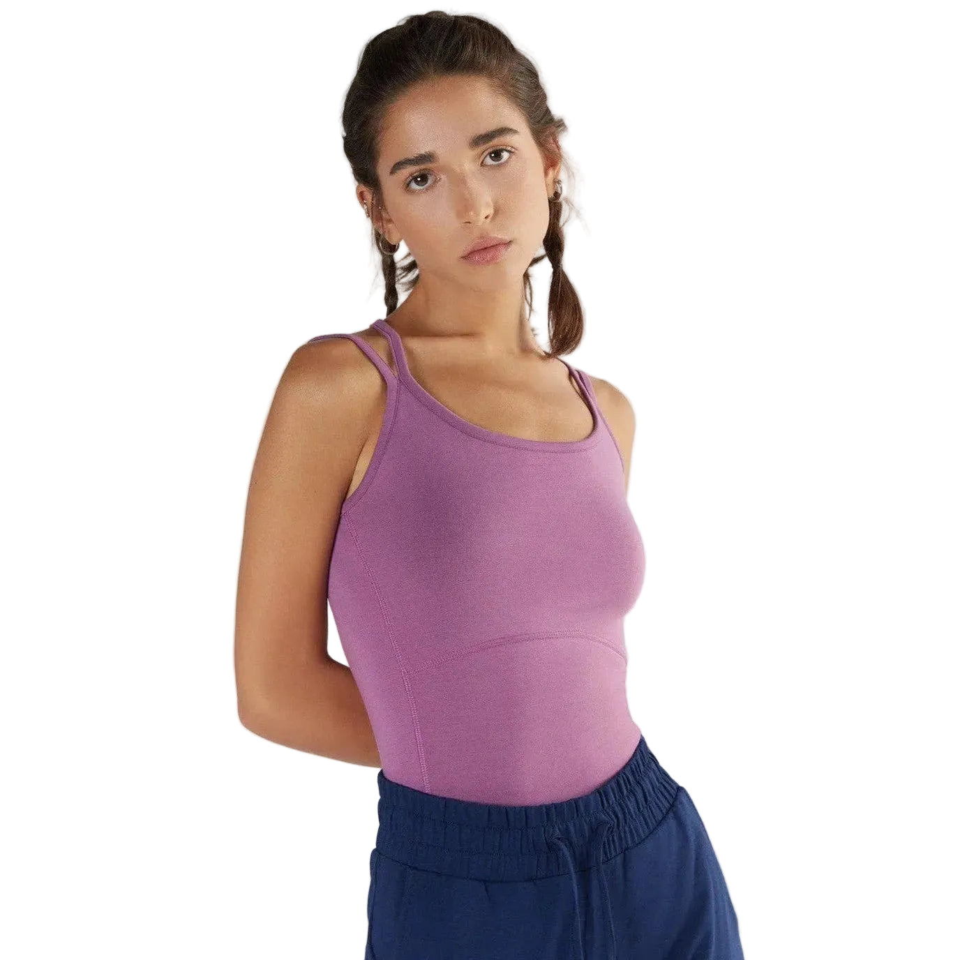 Woman wearing a purple tank top and blue pants on a white background