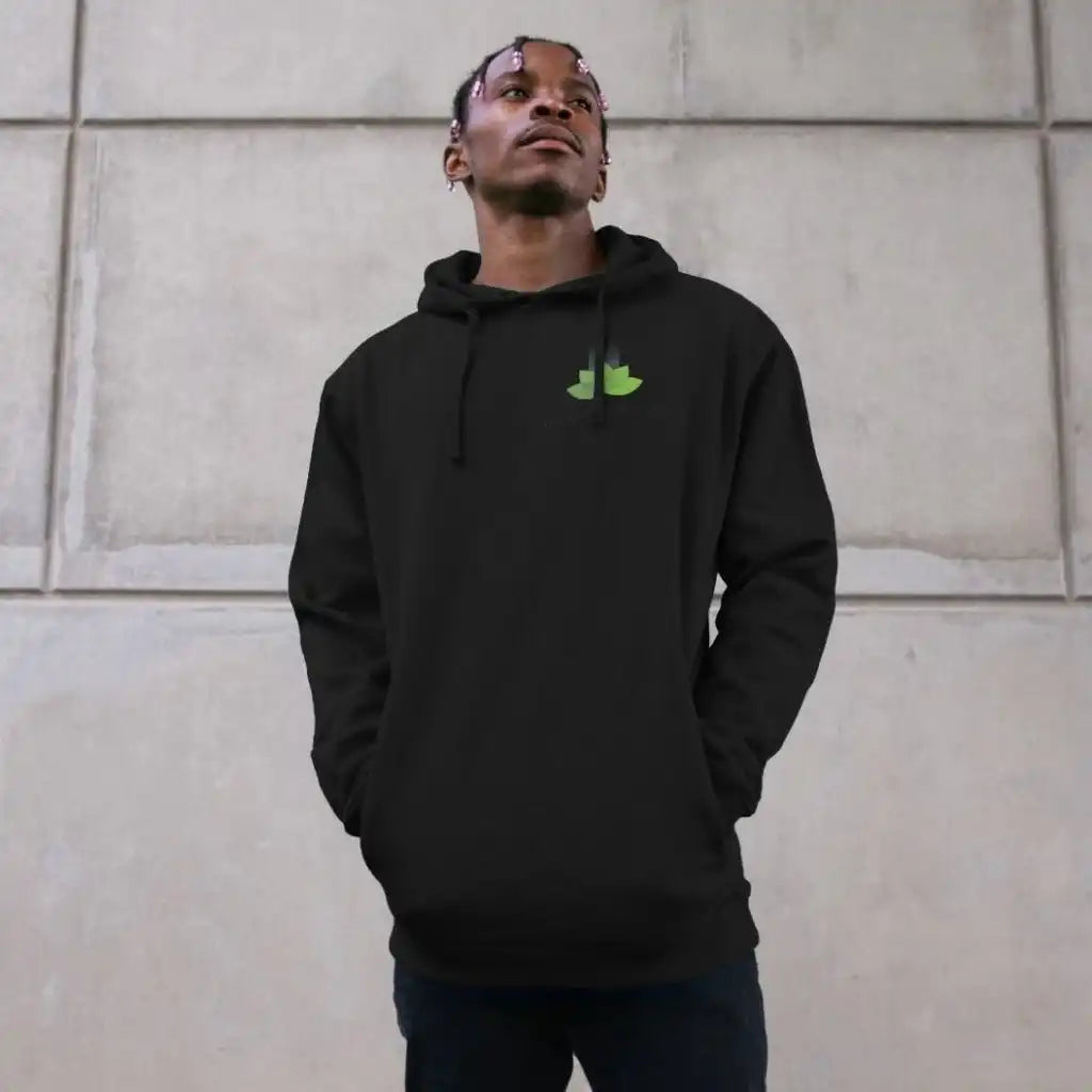 Person wearing a black hoodie with a green logo against a beige wall