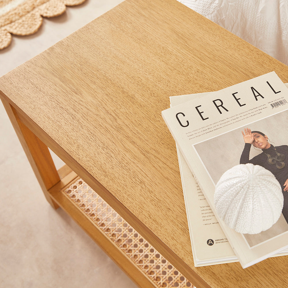 Close-up of the Bali bench’s wooden seat with a magazine and a white decorative ornament.