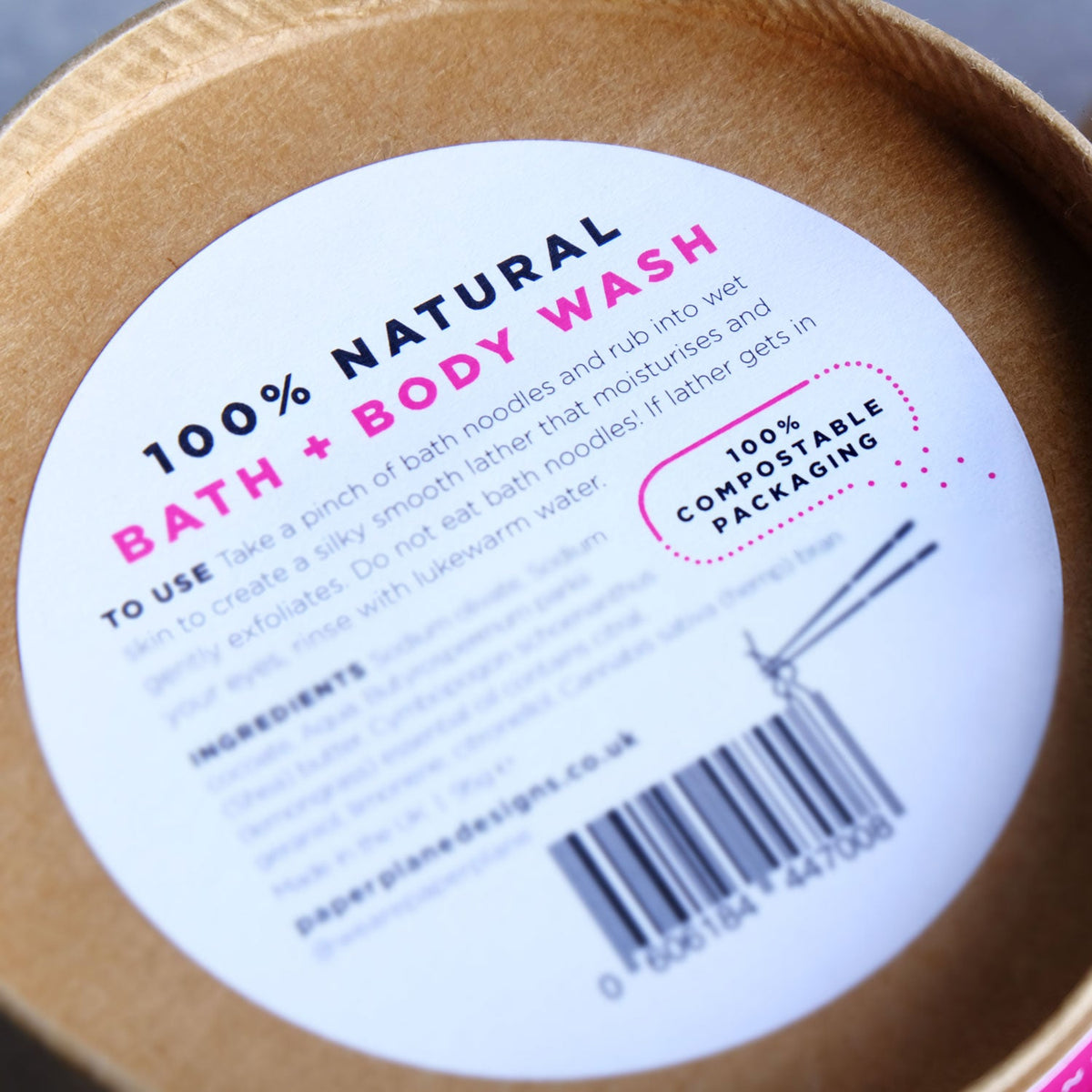 Close-up of a 100% natural bath and body wash container with compostable packaging label.