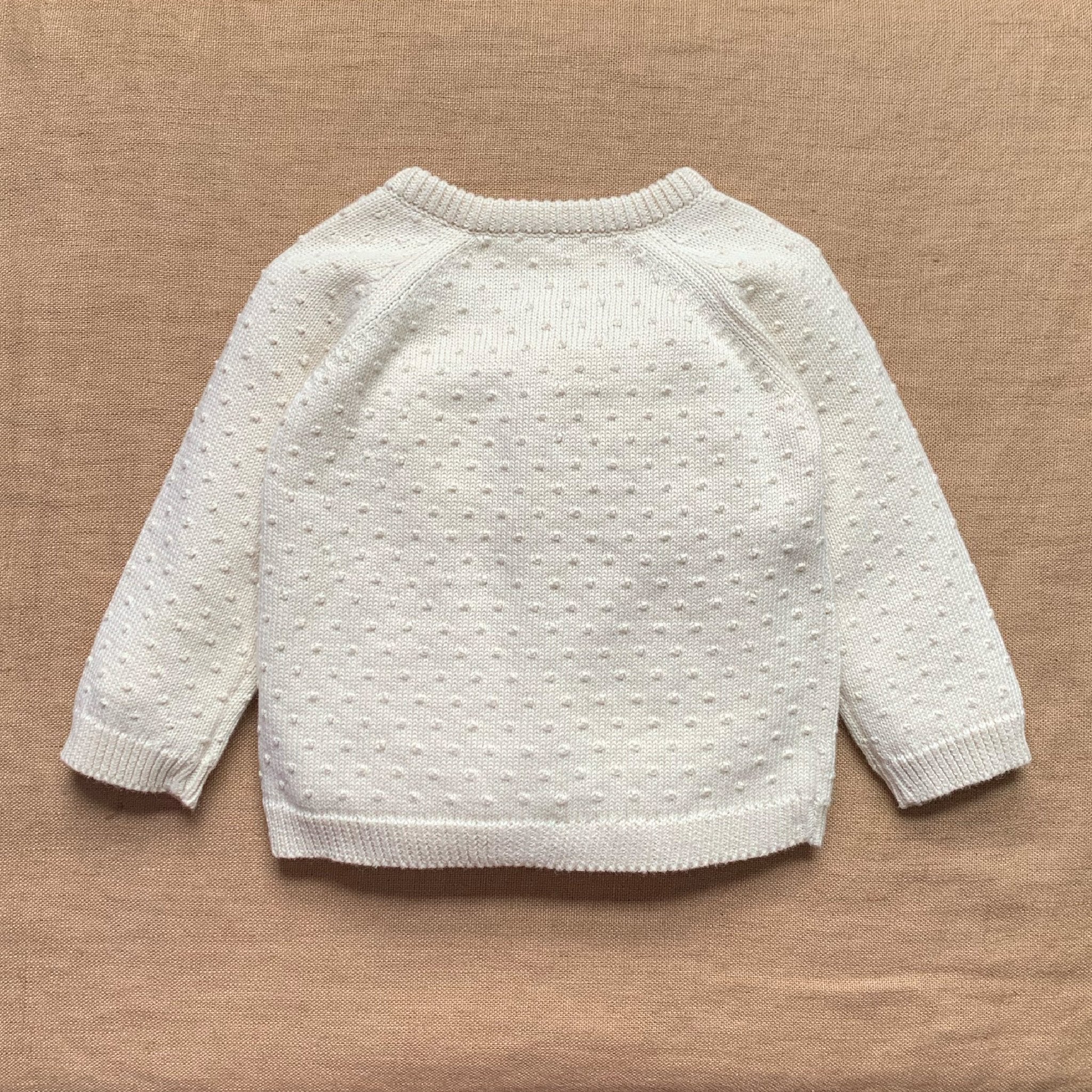 White textured sweater on a brown background