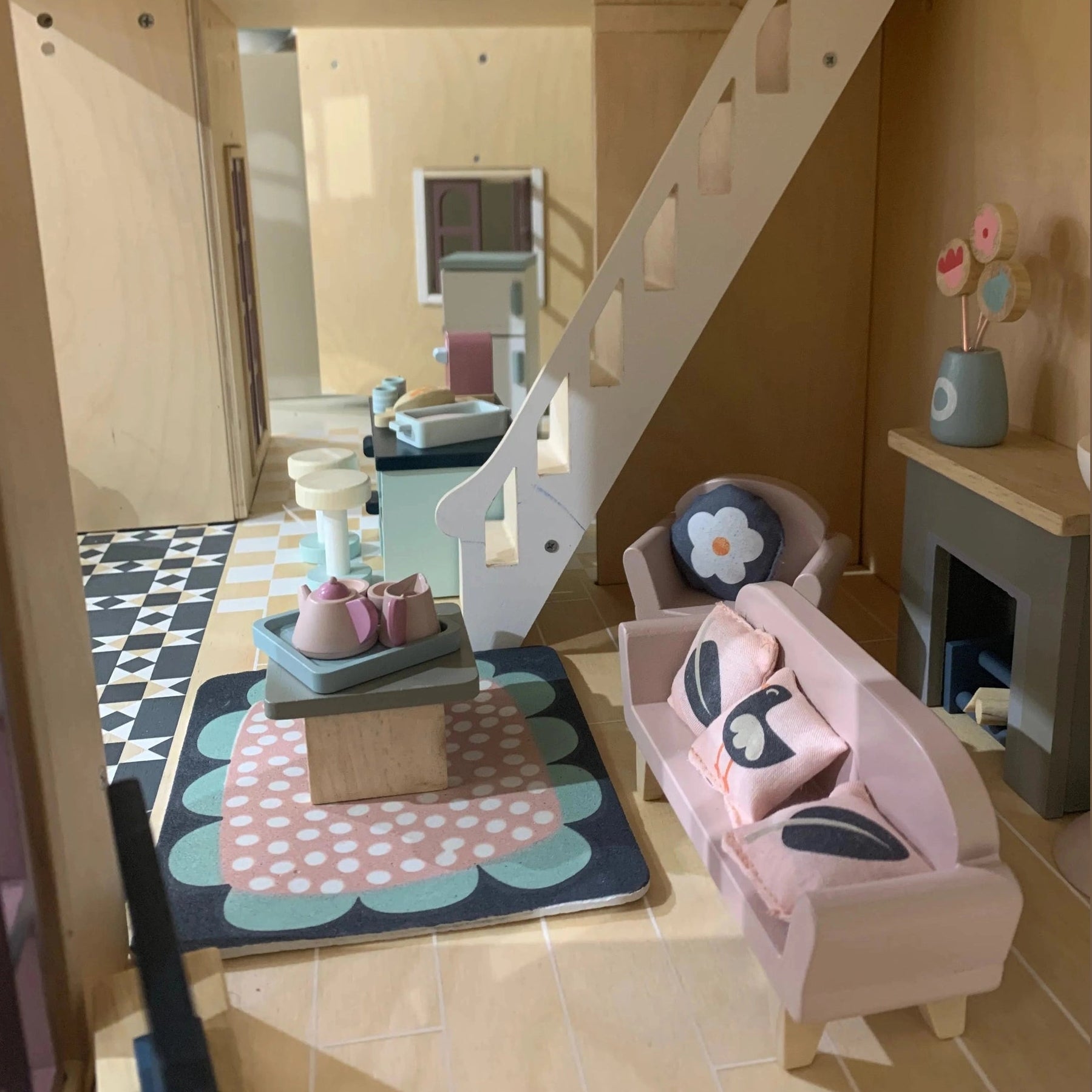 Children's dollhouse living room with dollhouse, furniture, and decor.