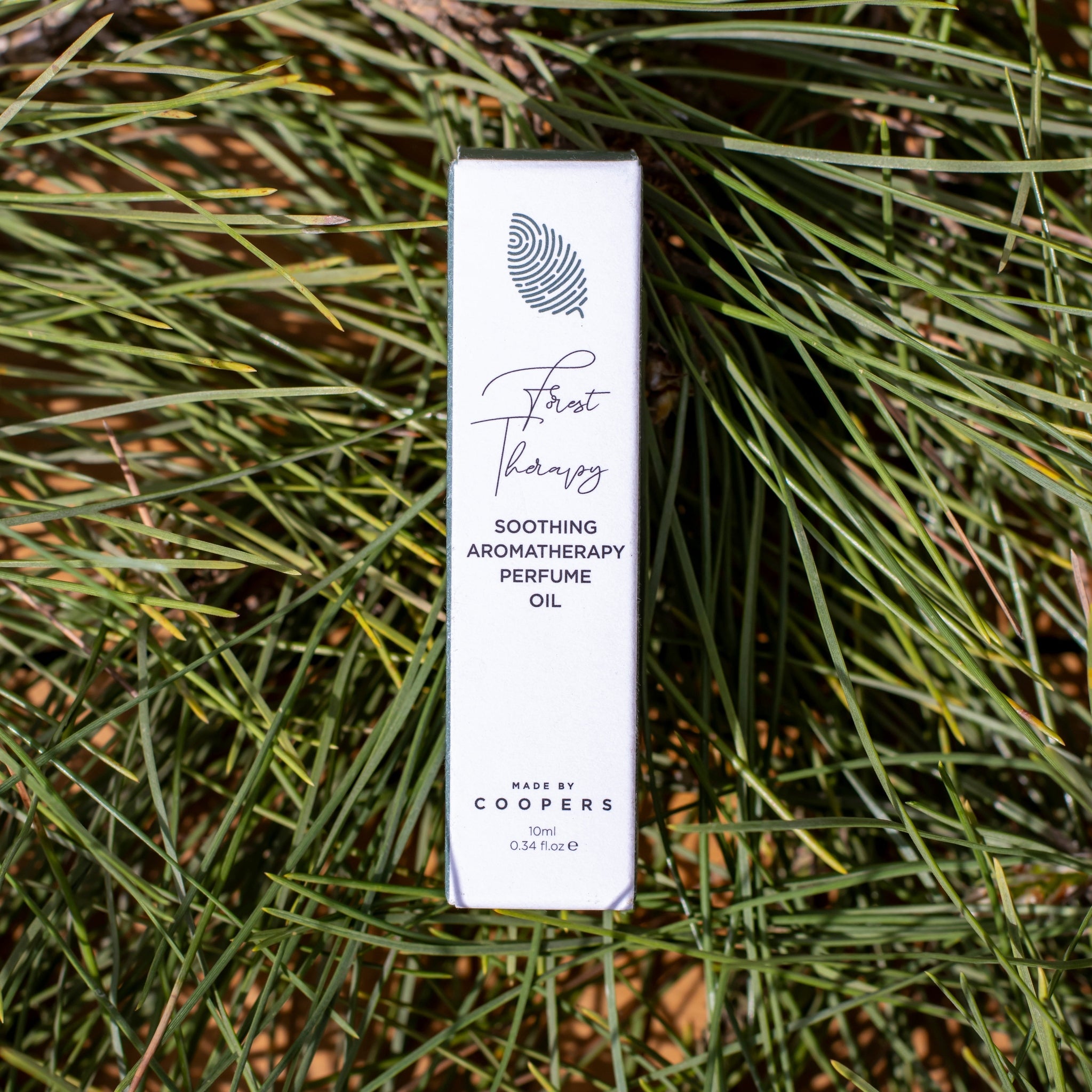 Perfume oil packaging on a grassy background