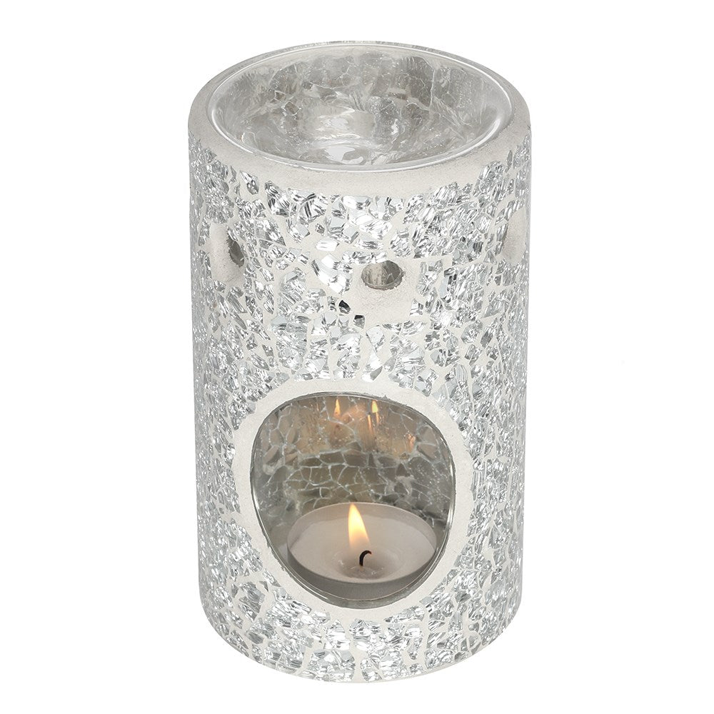Clear glass candle holder with a lit candle inside on a white background