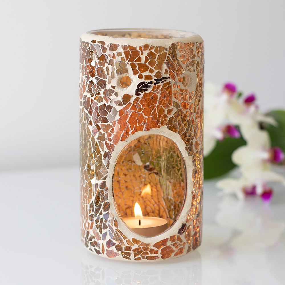 Mosaic candle holder with a lit candle inside, surrounded by flowers on a white background