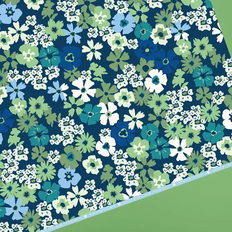 Floral pattern wrapping paper with blue, green, and white flowers on a blue background