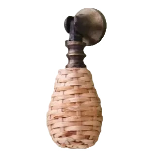 Decorative rattan cupboard handle with woven design and metal accents on a plain background