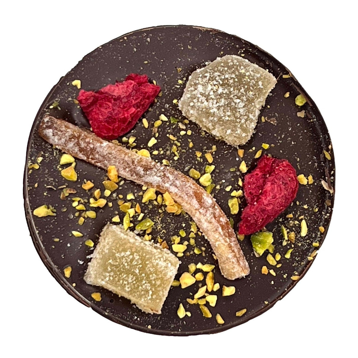 Assorted dried fruits and nuts on a dark chocolate disc with a white background