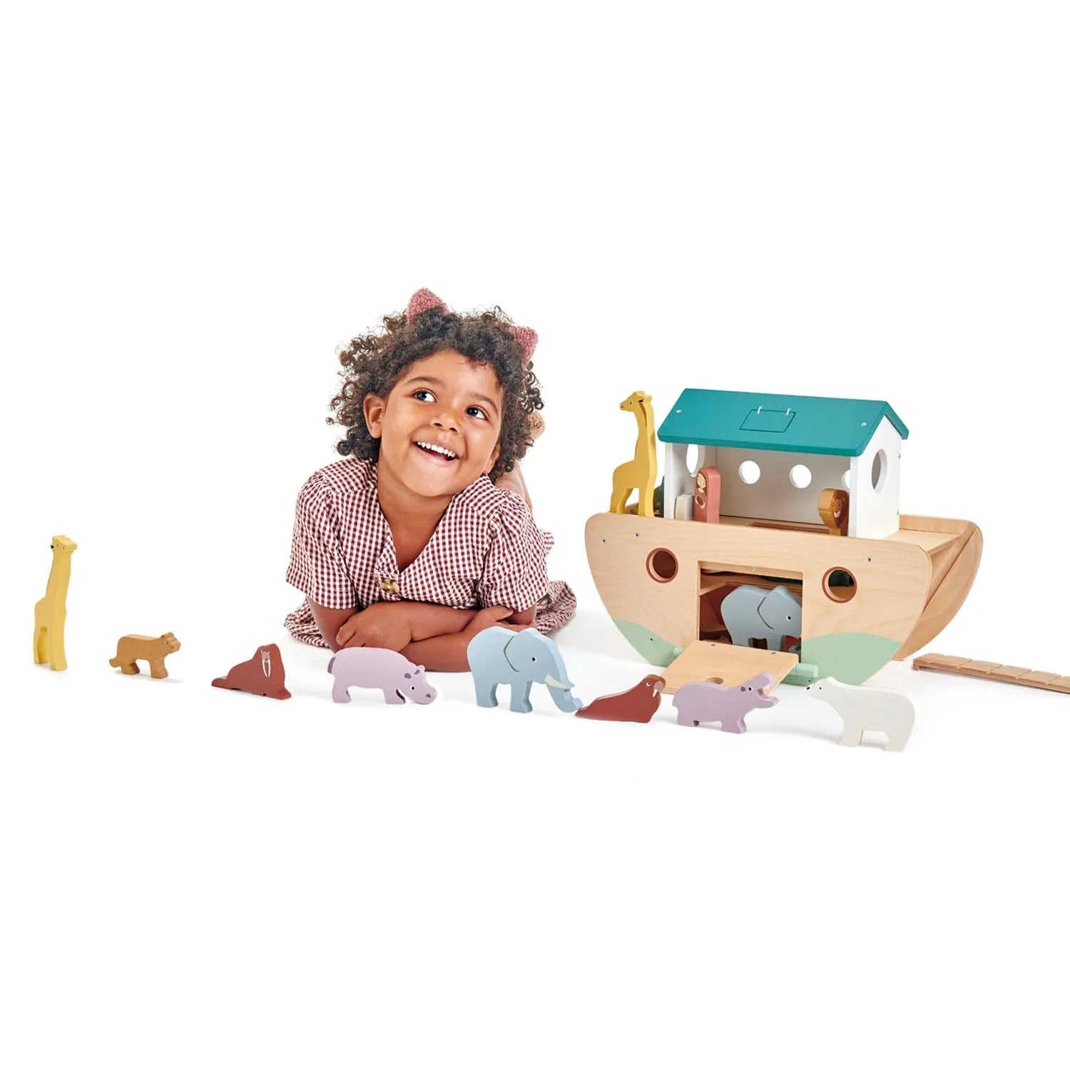 Child playing with a wooden toy Noah's Ark on a white background