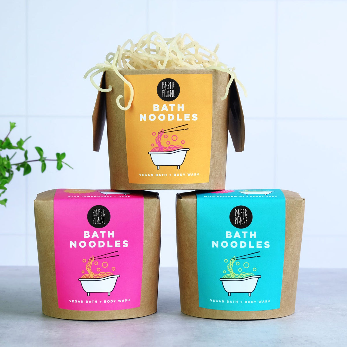 Three packages of Bath Noodles with colorful labels on a light background