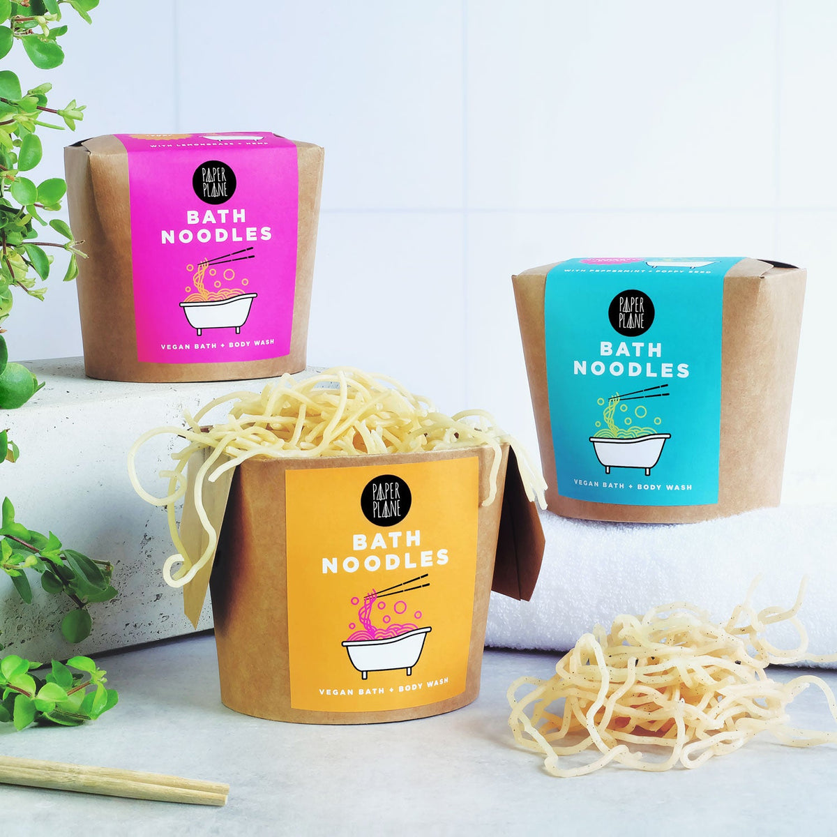 Bath noodles in a cardboard container with colorful packaging on a light background.