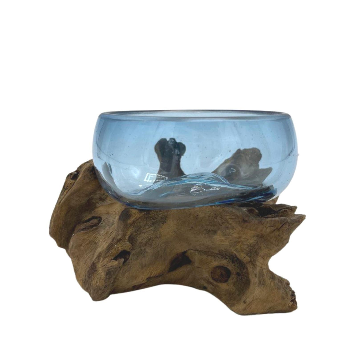 Side view of a blue glass bowl resting on a sculptural wooden base