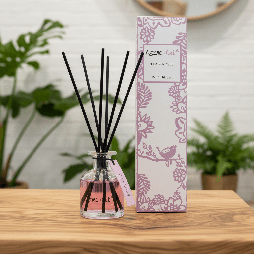 Reed diffuser with packaging on a wooden surface, plants in the background
