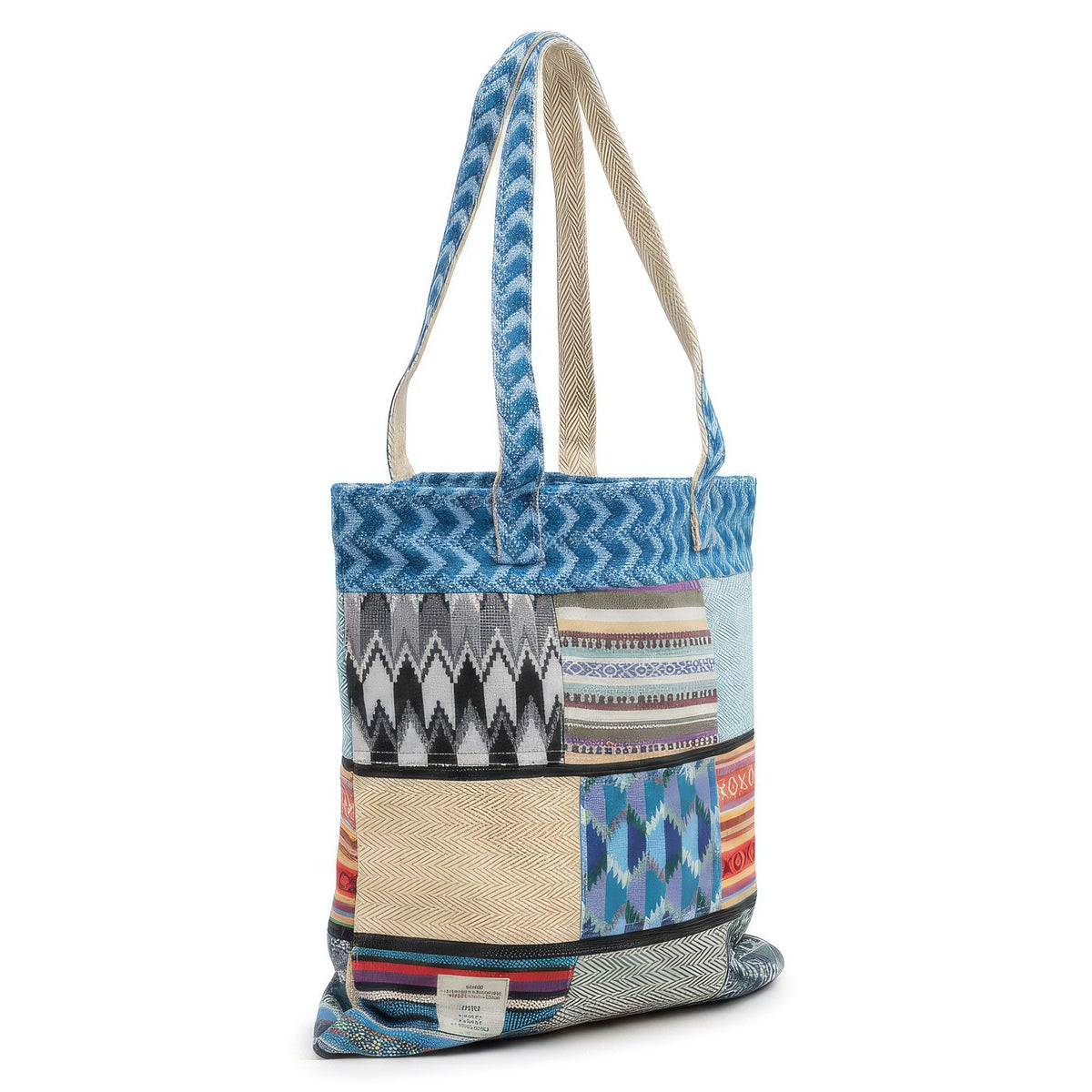 Kathmandu cotton and hemp patchwork tote with blue patterned shoulder straps on a white background