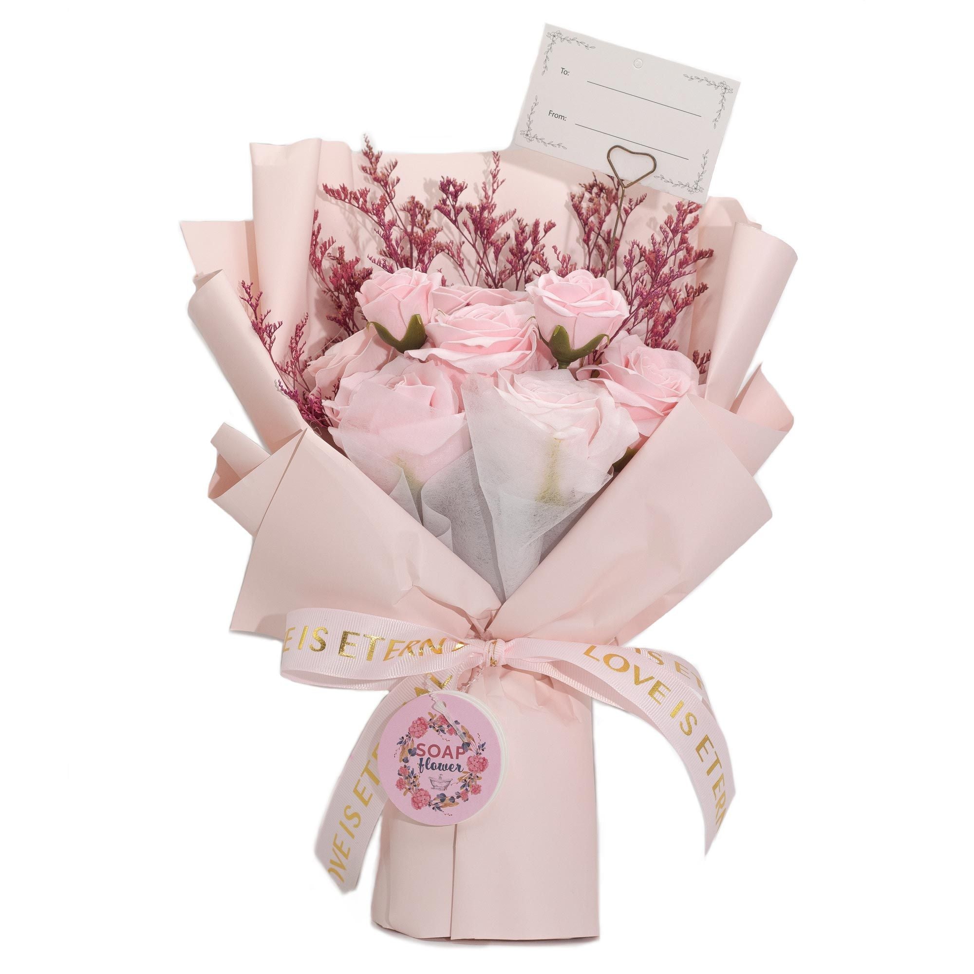 Bouquet of pink rose soap wrapped in light pink paper with a ribbon on a white background