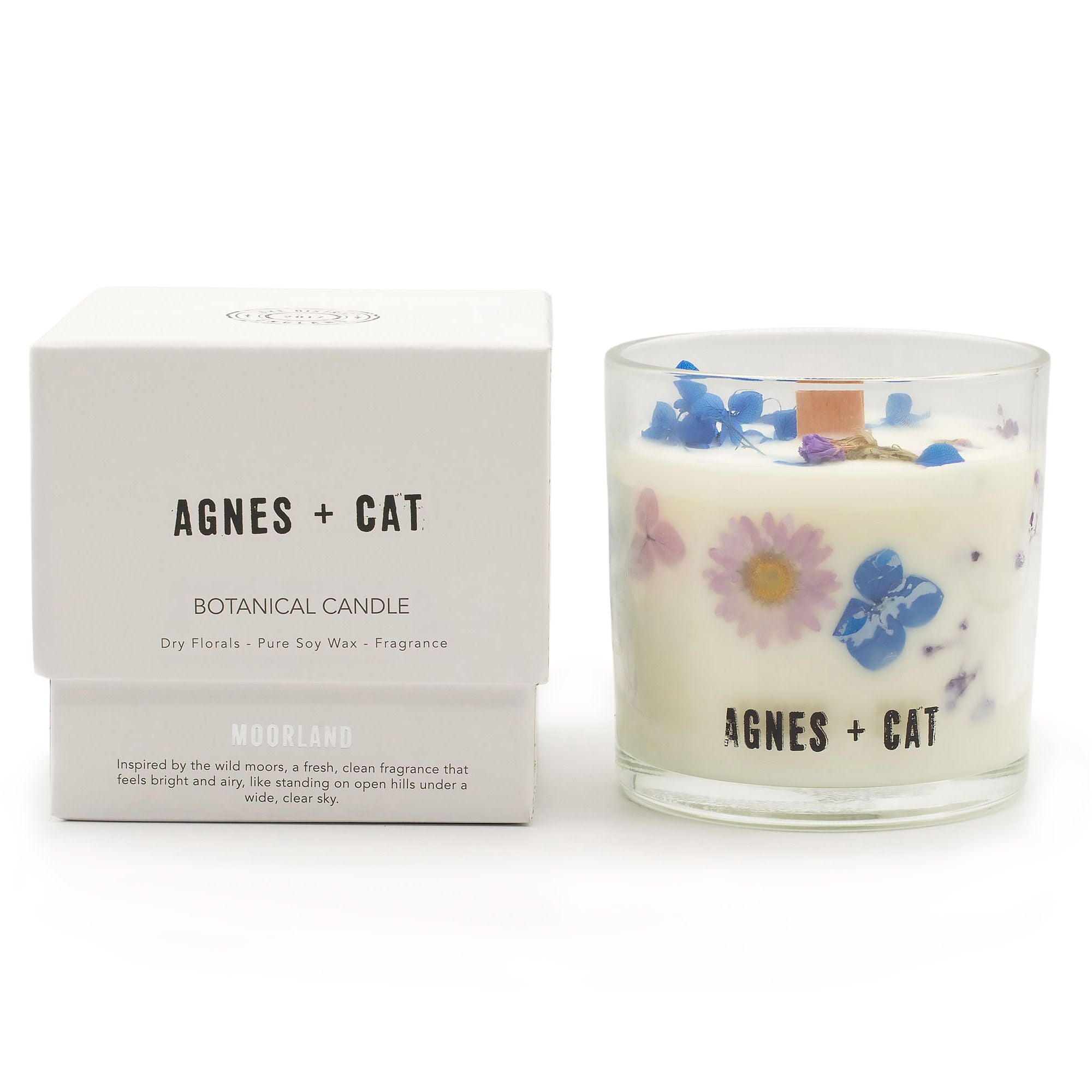 Botanical candle with floral design and matching box labeled 'Agnes + Cat' on a white background