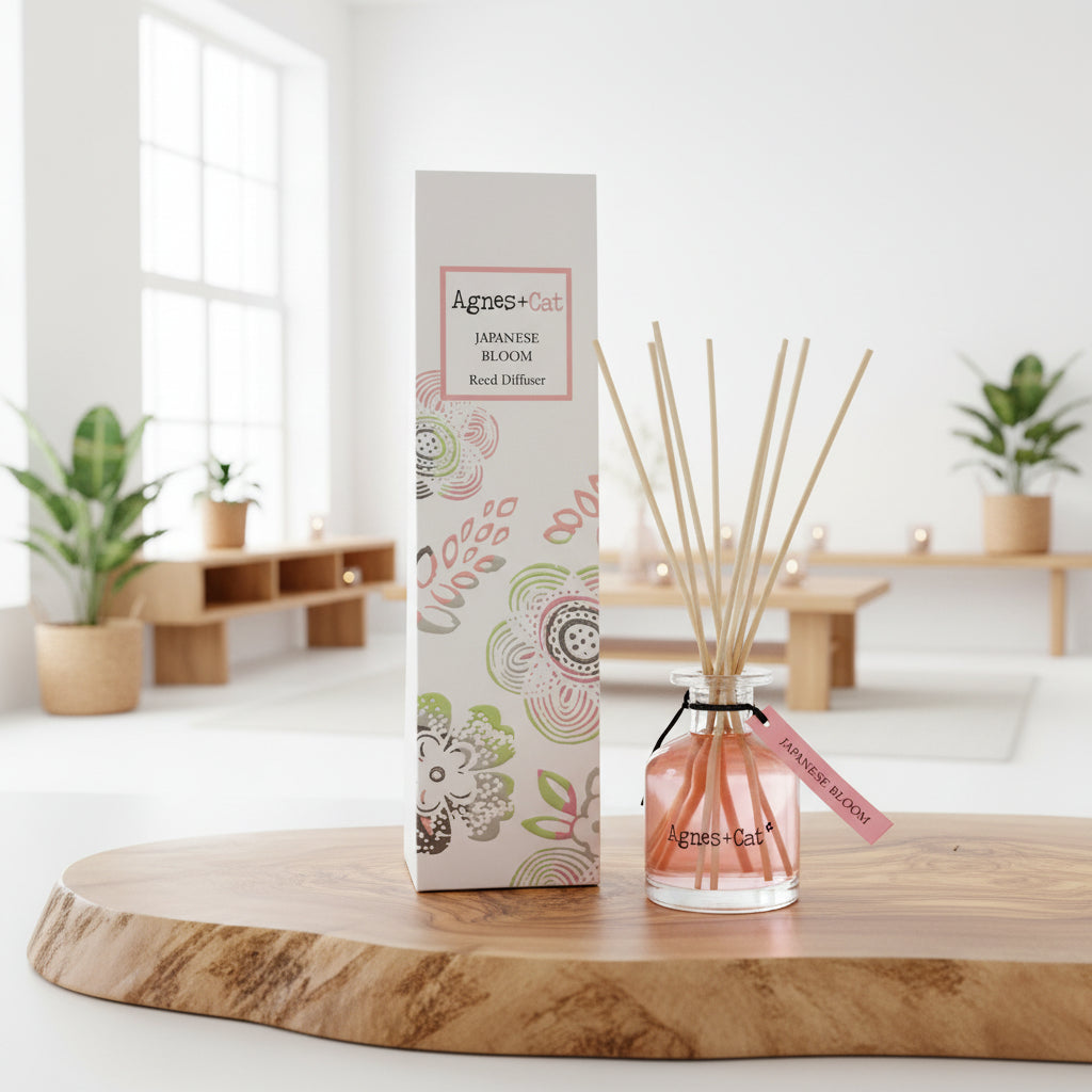 Agnes & Cat diffuser and packaging on a wooden surface with a blurred indoor background