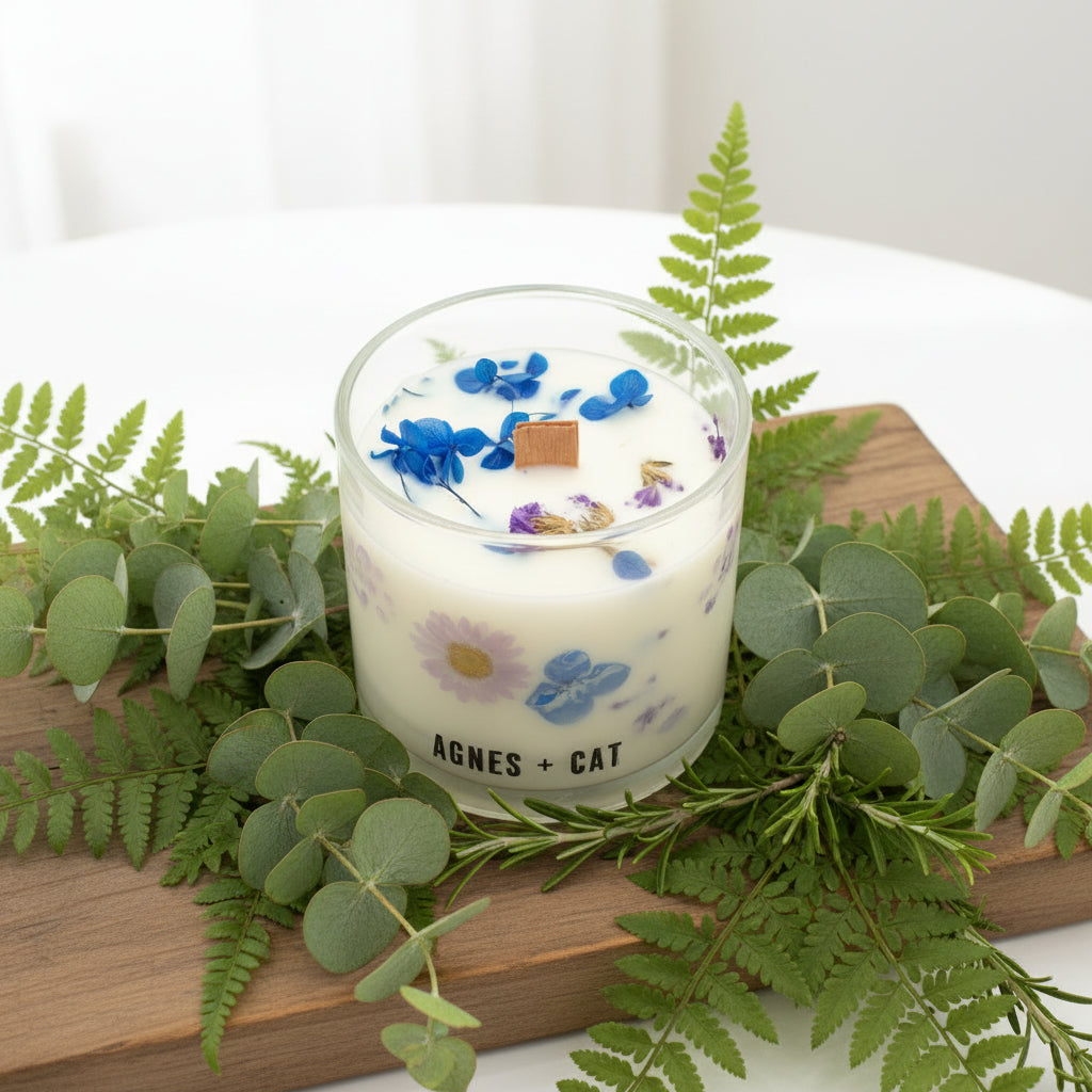 Candle with floral design and 'Agnes + Cat' branding on a white background
