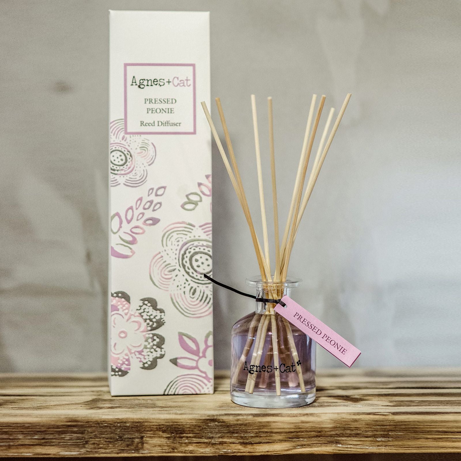 Pressed Peonies reed diffuser by Agnes + Cat, featuring a glass bottle with black fibre reeds and decorative floral box