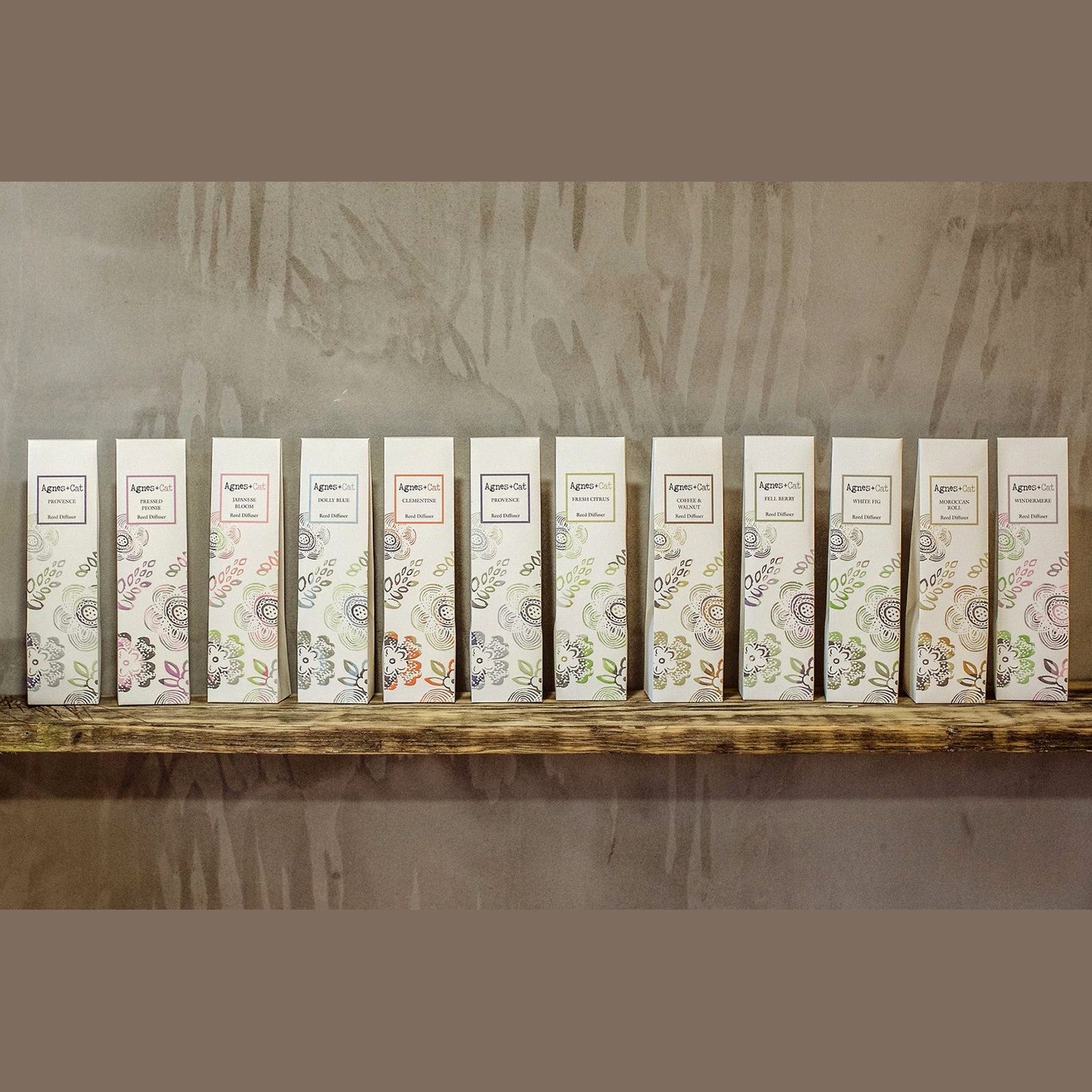 Pressed Peonies reed diffuser by Agnes + Cat, with a floral design and a lavender glass bottle with black reed sticks.