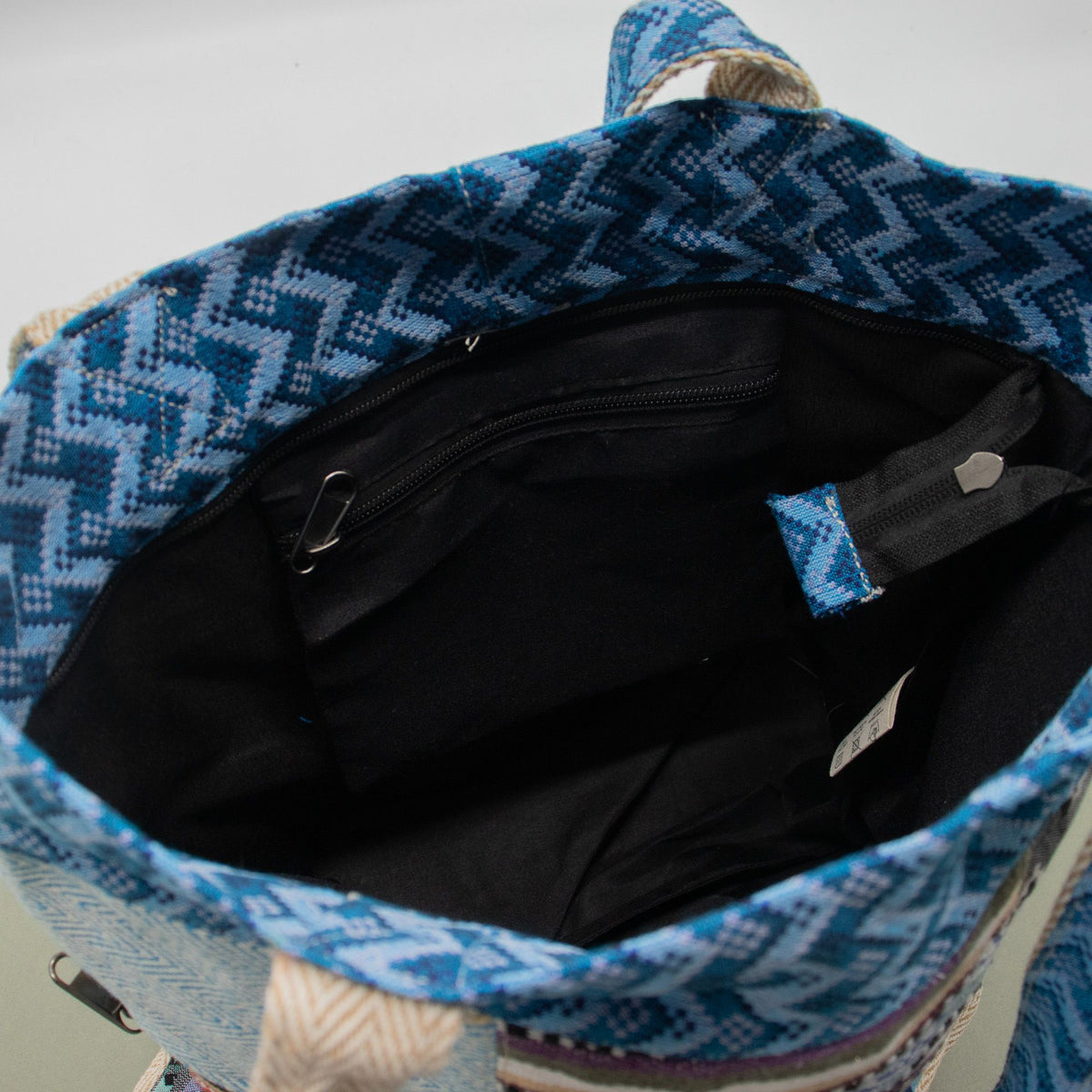 Inside the Kathmandu tote: black lining, an internal zip pocket, and a press-stud fastening.