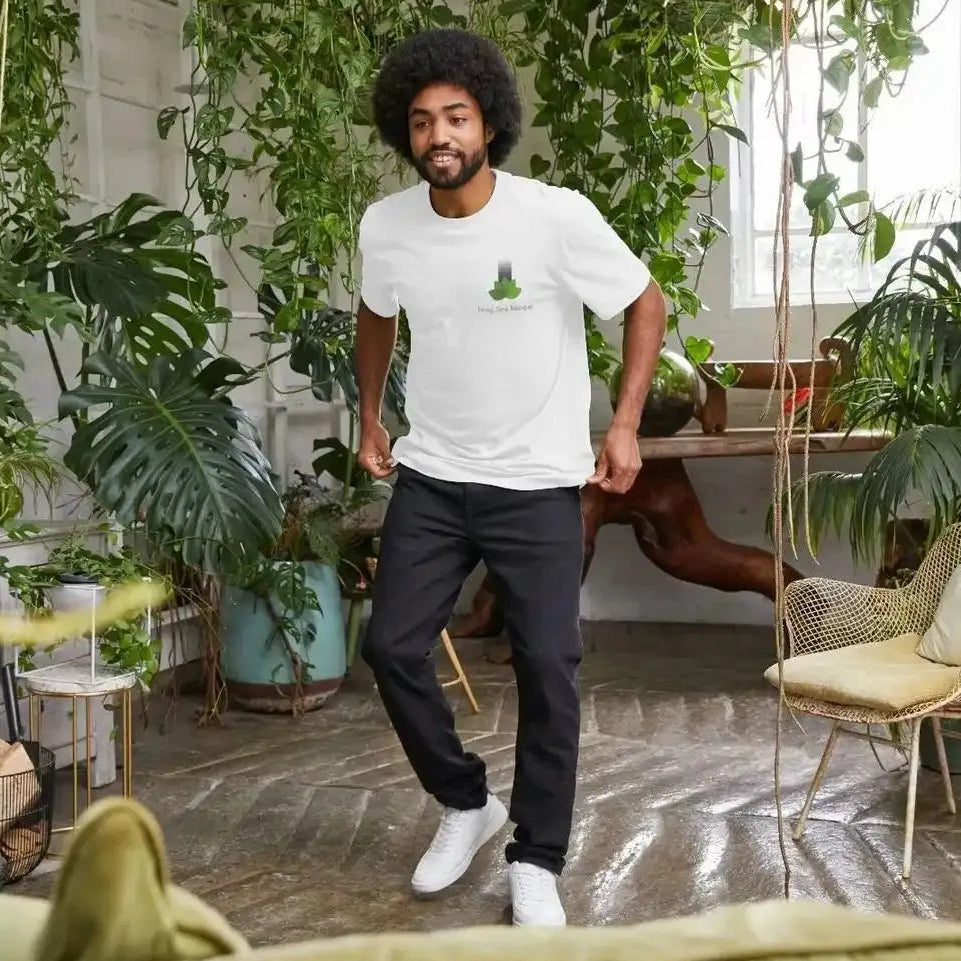 Man wearing a white t-shirt with a logo in a room filled with plants