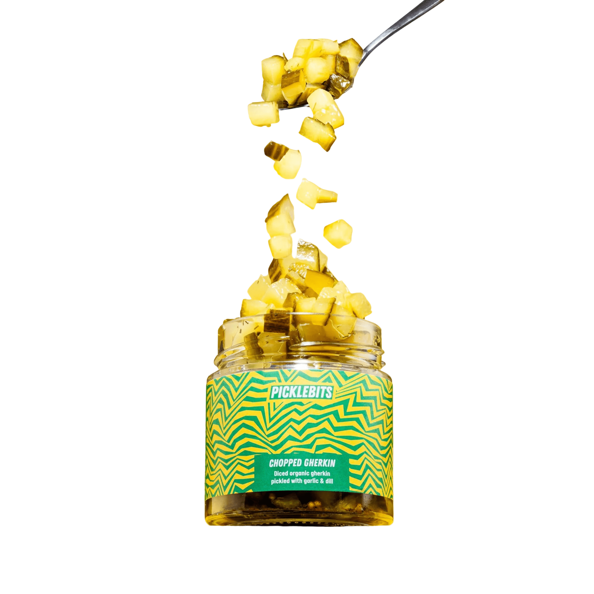 Jar of Picklebits chopped pickles with a spoonful being poured over, on a white background