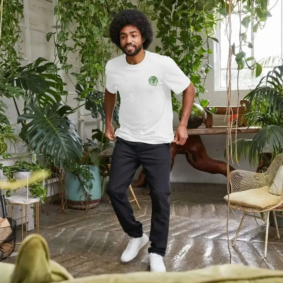 Man wearing a white t-shirt with a logo in a room filled with plants