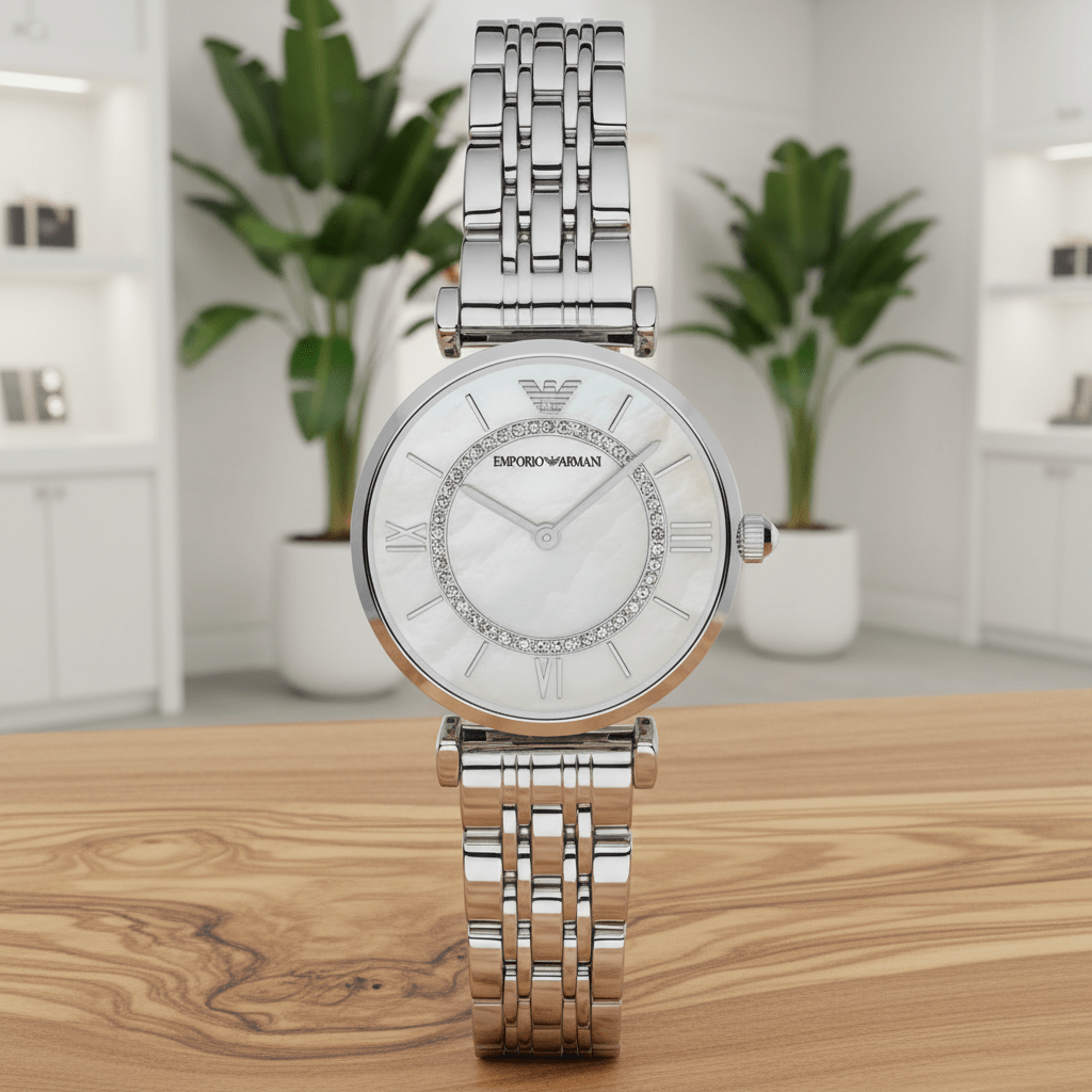 Silver watch with a white face on a wooden surface, with plants in the background