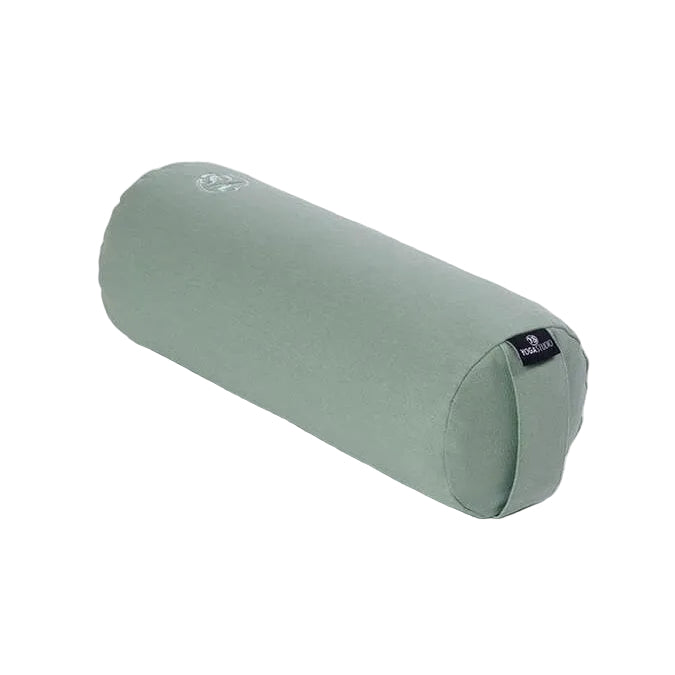 A sage green cylindrical yoga bolster pillow with a small black brand tag on one end, shown on a plain white background.