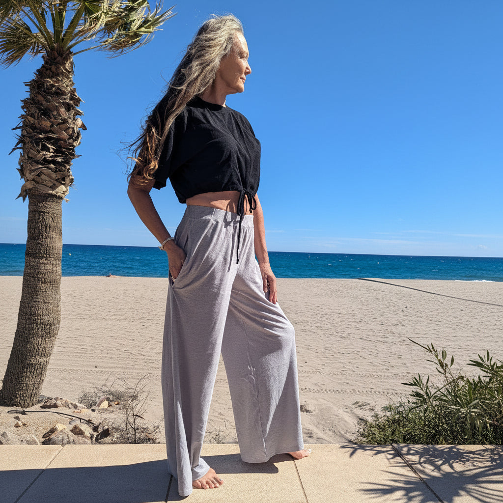 Woman standing on a beach with palm trees and clear blue sky